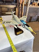 Left front view of model on stand with measuring tape showing length