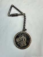 Entire keychain showing triangular clasp, chain and medallion