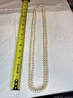 Full necklace alongside tape measure showing length exceeding 36 in