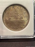 Reverse voyageur side of 1935 Canada dollar in holder