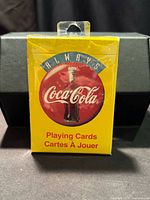 Front of sealed yellow Always Coca-Cola deck in plastic wrap
