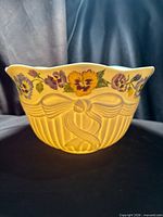Front view showing yellow exterior, ribbon bow motif and floral decoration