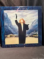 Front cover artwork showing Luba in black coat against mountainous backdrop