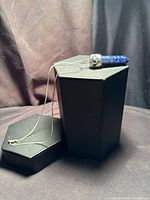Pendant on display box showing full chain and crystal point