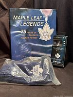 Group shot showing book front cover, sealed headphones box, and sealed mittens