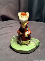 Front view of Beswick mouse figurine showing brown coat, hat, Race Card, green base