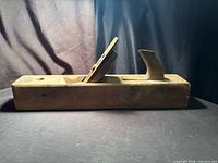 Full left side view of wooden jointer plane showing body, wedge and handle