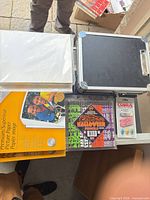 Top view showing paper packs, pencils, erasers and closed aluminum case