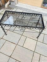 Full view of rectangular coffee table showing frame, glass top, and legs
