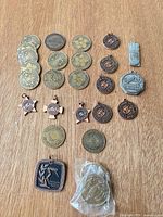 Entire assortment of medals, tokens and pendants laid out on wood surface