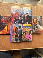 All six paperback novels laid out on table