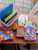 Group shot showing basket with books, blocks, puzzle cubes, squishy ball, mesh bag of toys and figure