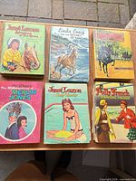 Six hardcover juvenile books laid out on tabletop