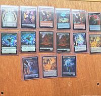 Fifteen sleeved foil token cards displayed front side up
