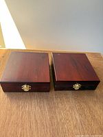 Two closed mahogany wood jewelry boxes side by side