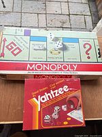 Monopoly and Yahtzee boxes stacked