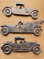 Overview of three cast metal car plaques