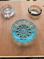 All three ashtrays grouped on wooden surface