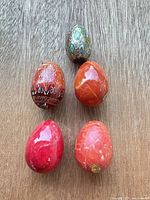 Group shot of five alabaster eggs on wood surface