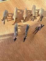 Eight carved wood animal figurines arranged in two rows