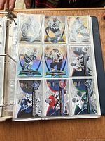 Open binder page showing nine Upper Deck hockey cards in plastic sleeves