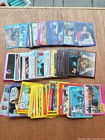 Three grouped stacks of assorted movie trading cards with various border colours