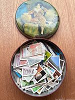 Open tin showing mixed trade cards inside