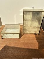 Both glass and brass jewelry boxes side by side