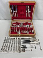 Open case with full flatware set displayed and additional pieces laid out