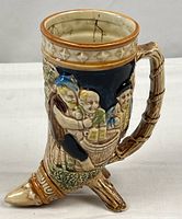 Full view of ceramic drinking horn mug/vase showing shape, handle, base