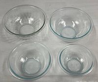 Four glass mixing bowls laid out to show sizes and styles