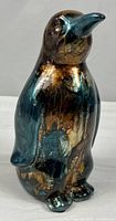 Front view of iridescent ceramic penguin figurine
