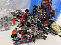 Overall view of unsorted Lego pile in blue bin with organizer and zip bag