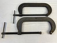 Two large PROTO C-clamps laid flat showing overall form