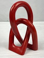 front view of red interlocking soapstone sculpture