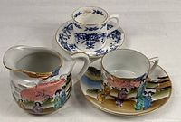 Group shot showing all five pieces: Japanese Satsuma-style creamer, teacup, saucer, and Carpentree teacup & saucer