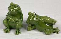 Both green ceramic frog shakers together