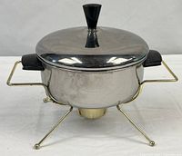 Pan on brass-tone stand with lid in place