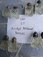 Group of eight cut glass perfume bottles with diamond pattern and metal tops