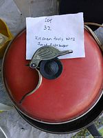 Red frying pan with metal bird press on top