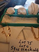 Five gold-tone anklets displayed in tray with two styles visible
