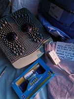Lot overview showing foot massager, Aleve Direct Therapy box, sling and heating pad