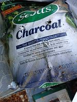 Scotts Charcoal 10 qt bag with visible wear and openings