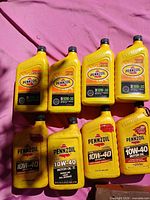 Eight loose Pennzoil bottles showing both 10W-30 and 10W-40 labels