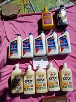 Group of all oil and fluid bottles laid out on pink cloth