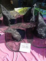 Four witches hats with lace overlay displayed on table