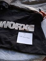 Black Worx lawn bag with logo and note