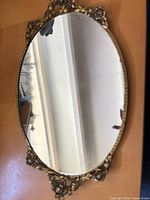 Full view of oval mirror showing frame and glass