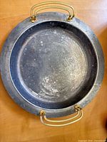 Top view of round silver-plated tray with gold-tone handles