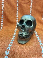 front view of small silver skull figurine